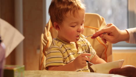 little boy eats porridge