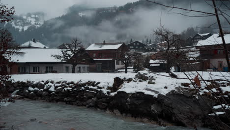 Serene-view-of-the-Weisse-Lütschine-river-in-Lauterbrunnen,-Switzerland,-captured-on-a-tranquil,-snowy-winter-day,-showcasing-the-ethereal-beauty-of-nature