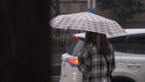 woman sheltering underneath umbrella