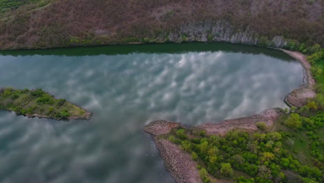 drone shot of a scenic lake with forested hills and a small island