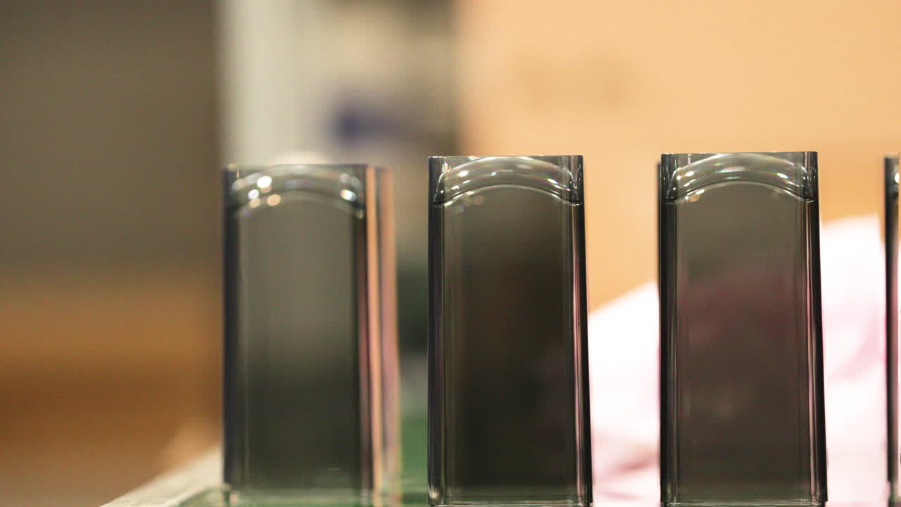 primer plano de los productos de plástico moldeado que libera una maquinaria automática en una empresa de moldeo por inyección