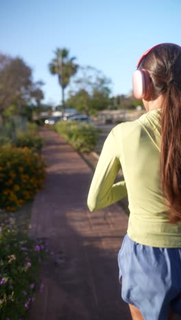 mujer corriendo al aire libre con auriculares