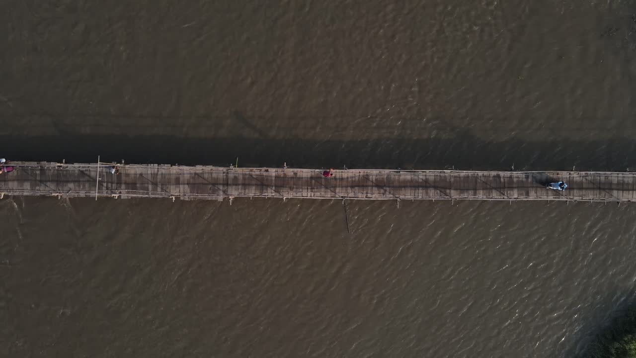 Aerial footage shows a wooden bridge spanning the Progo River, passable by motorbikes. As a link between the villages of Bantul and Kulonprogo.