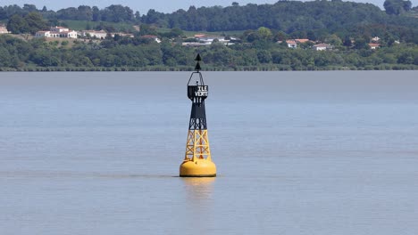 buoy gently sways in calm river waters