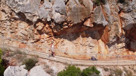 Tourist-Girl-Walks-to-Hidden-Pasjaca-Beach-in-Dalmatia,-Croatia---Aerial-Trucking-Pan