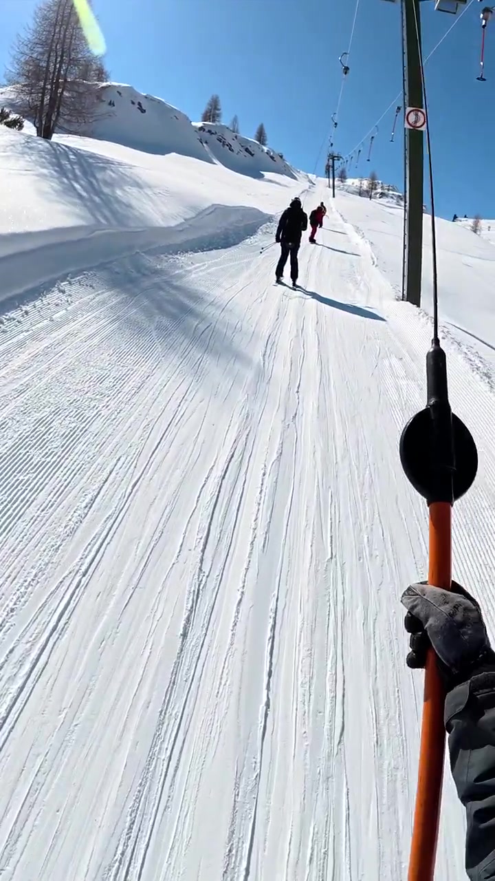 Sciatore che sale su una sciovia a T su una montagna innevata