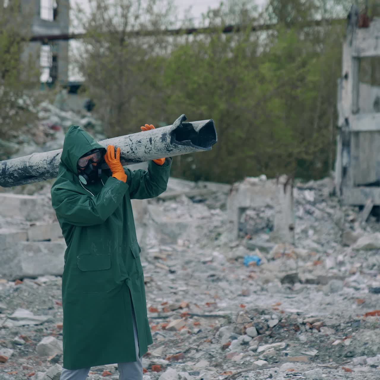 Person in gas mask on ruins. Man in protective clothing and gas mask walking through the ruined city