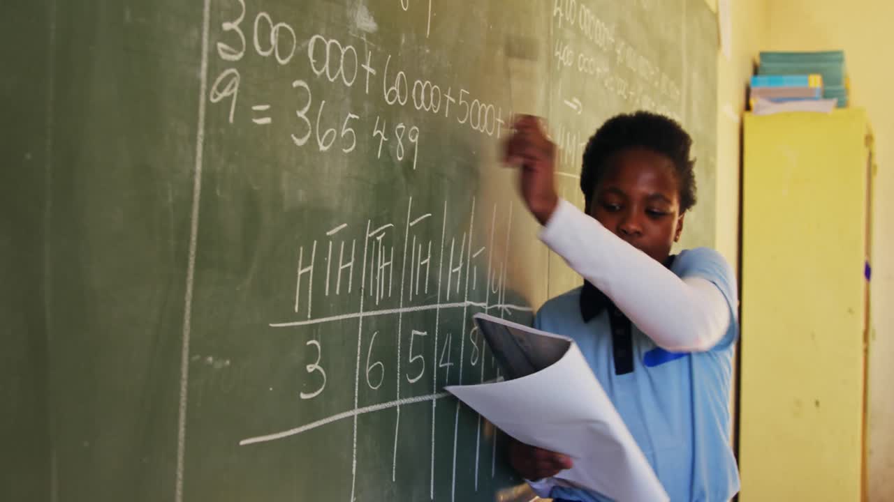 Young schoolgirl standing at the blackboard in class 4k
