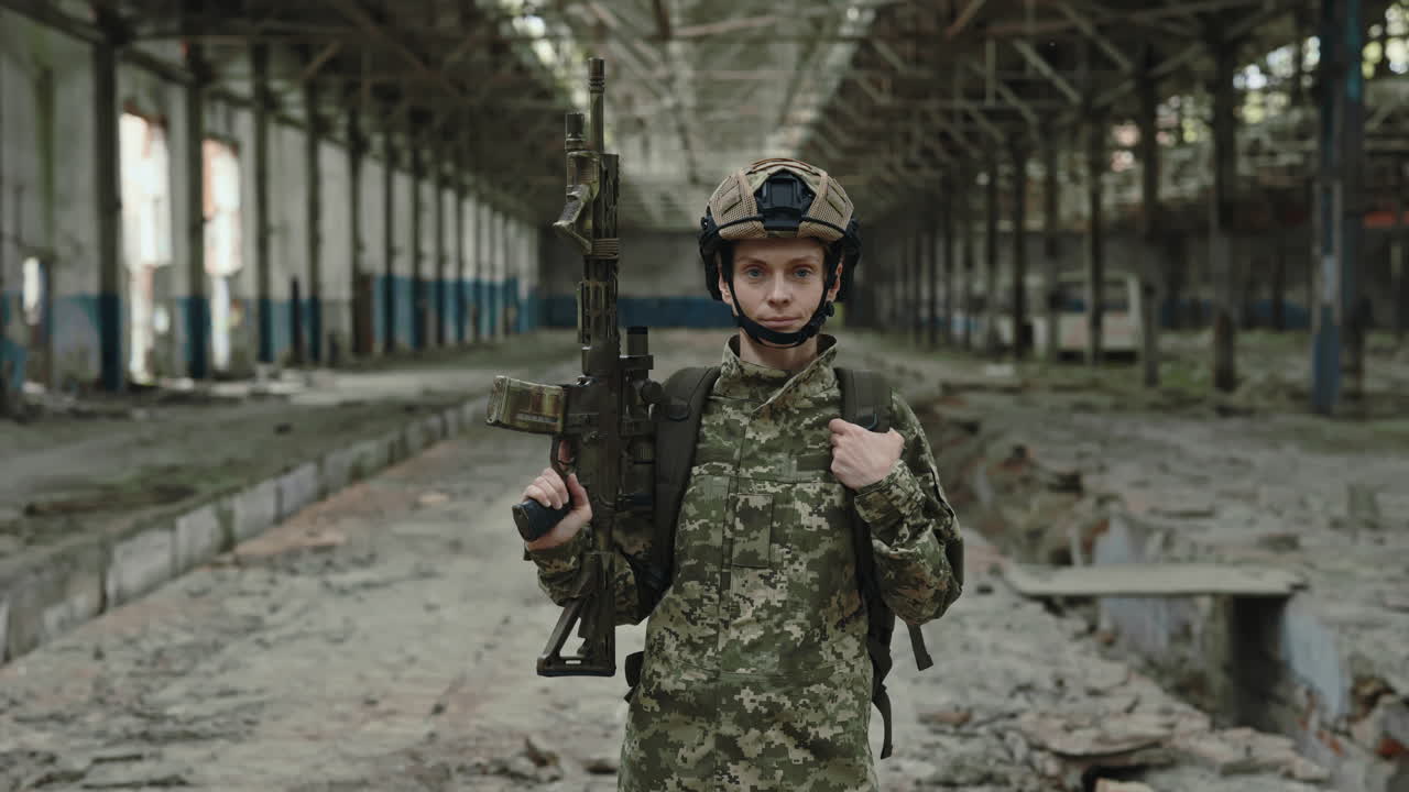 Woman Soldier in Military Uniform with Rifle in Abandoned Factory