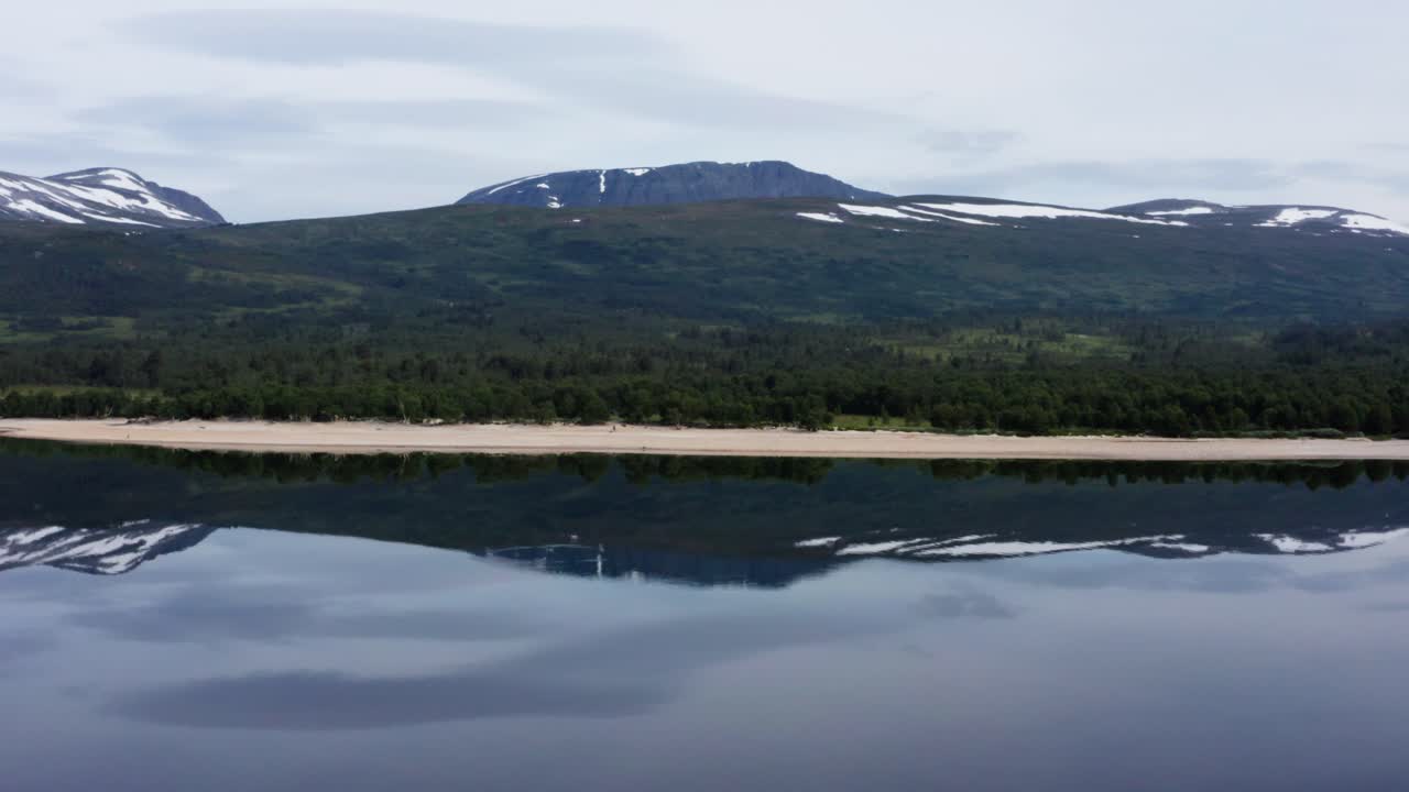 Riflessi Perfetti delle Montagne sull'Acqua del Lago Gjevilvatnet a Oppdal, Norvegia, con uno Scenario di Distesa Sabbiosa e Paesaggio di Foresta Verde Lussureggiante