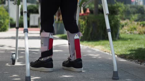 person with leg brace walking with walker