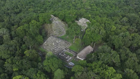 old maya ruins in middle of lush green jungle at yaxha near tikal, aerial