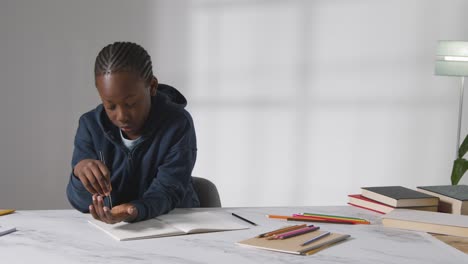 Studioaufnahme-Eines-Jungen-Am-Tisch,-Der-Darum-Kämpft,-Sich-Auf-Schulbuch-3-Zu-Konzentrieren