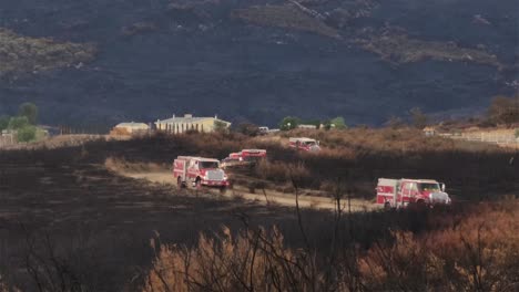 vehículo de emergencia conduciendo en un camino de tierra con arbustos quemados en el lado de la carretera fairview fuego california