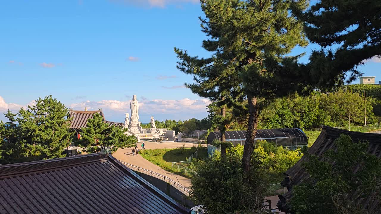 Zoom out from Avalokiteshvara or Hyuhyuam Sea Guanyin Statue at Hyuhyuam Hermitage temple and the surrounding ocean in Yangyang, South Korea, popular travel destination