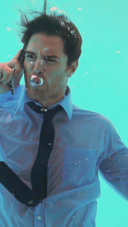 un hombre de negocios bajo el agua hablando en su teléfono inteligente.