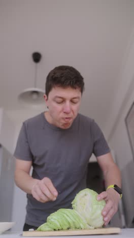 man eating and cutting cabbage