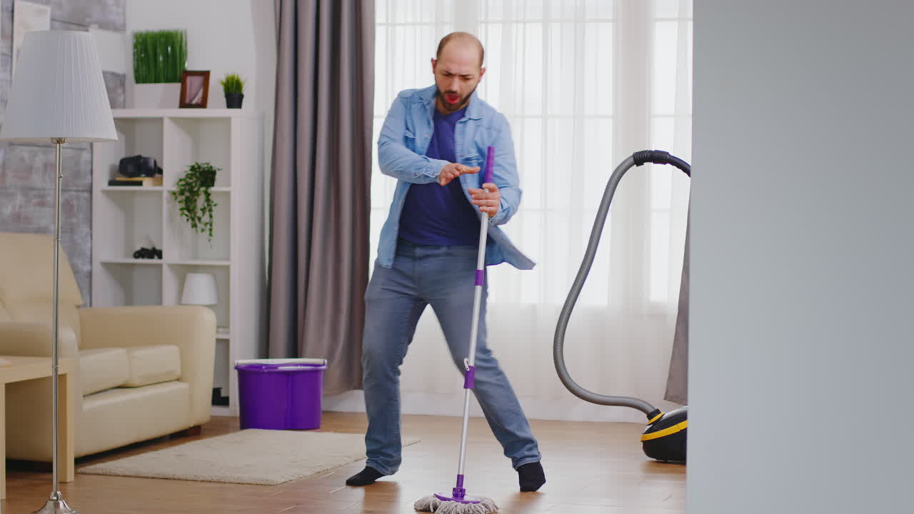 hombre gracioso limpiando el apartamento.