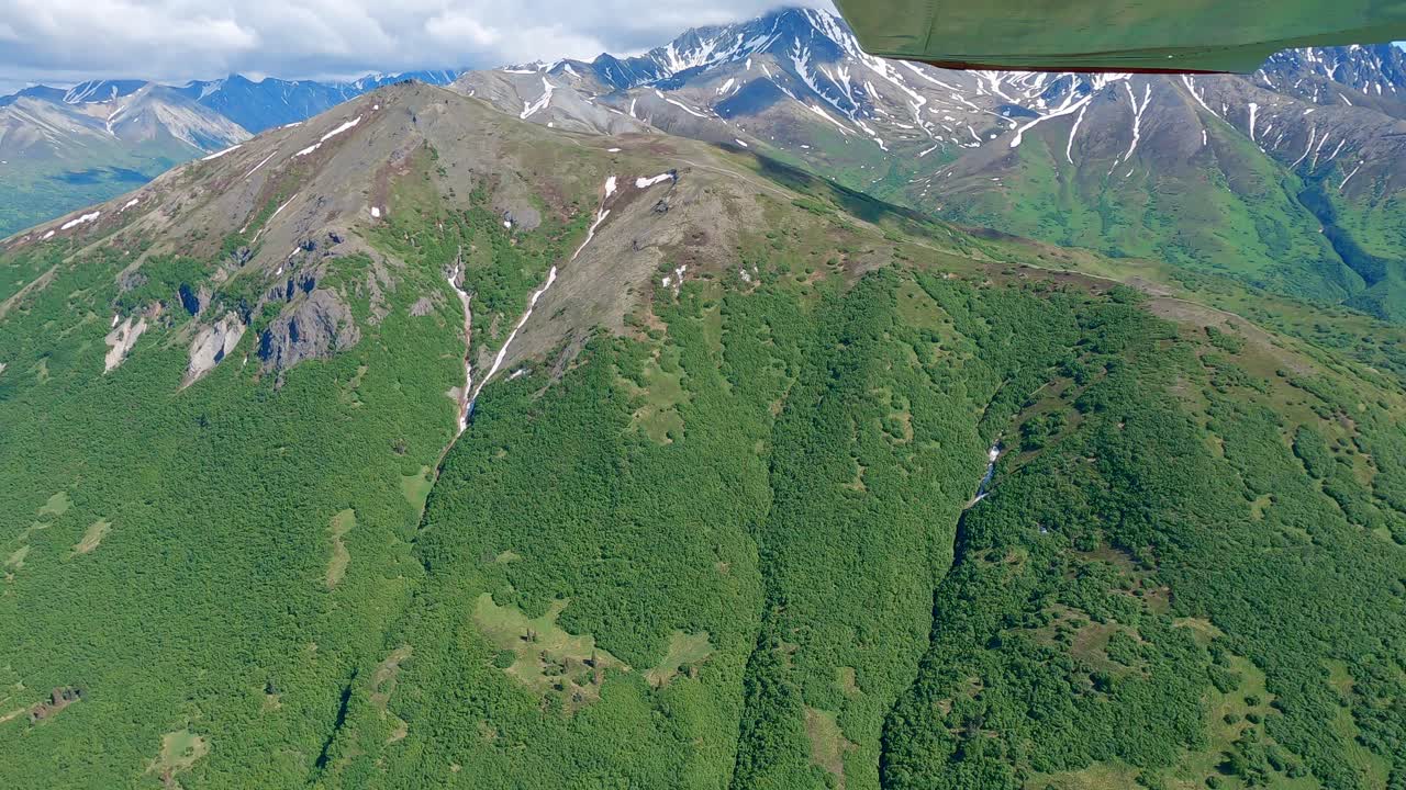 vuelo en avioneta sobre una remota montaña en la cordillera talkeetna de alaska, al este de la ciudad de palmer.