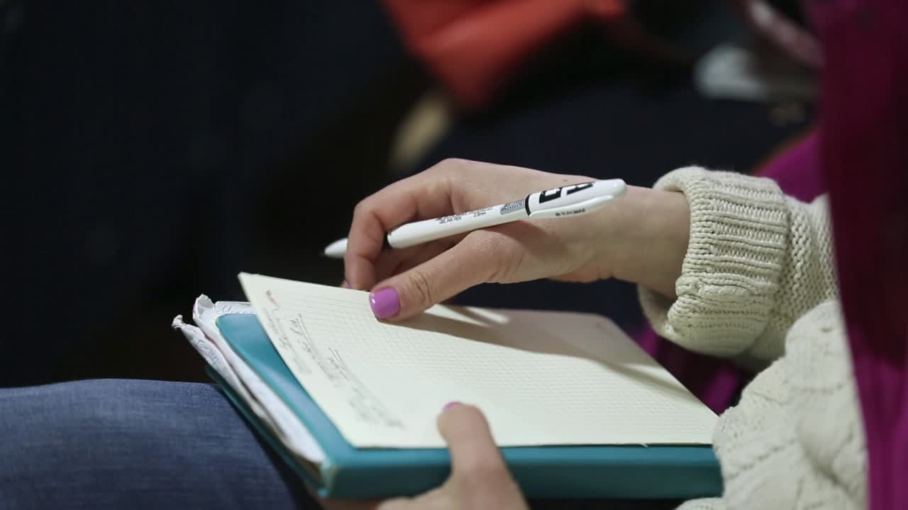 Hands Making Notes At The Conference. Close-up of hands holding pens and making notes at the conference