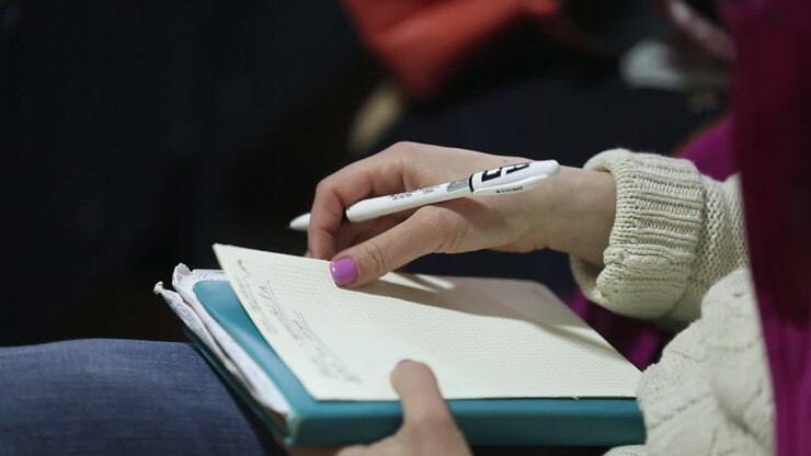 Hands Making Notes At The Conference. Close-up of hands holding pens and making notes at the conference