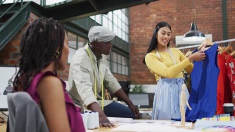 Happy-diverse-fashion-designers-wearing-the-tape-measures-discussing-work-at-office