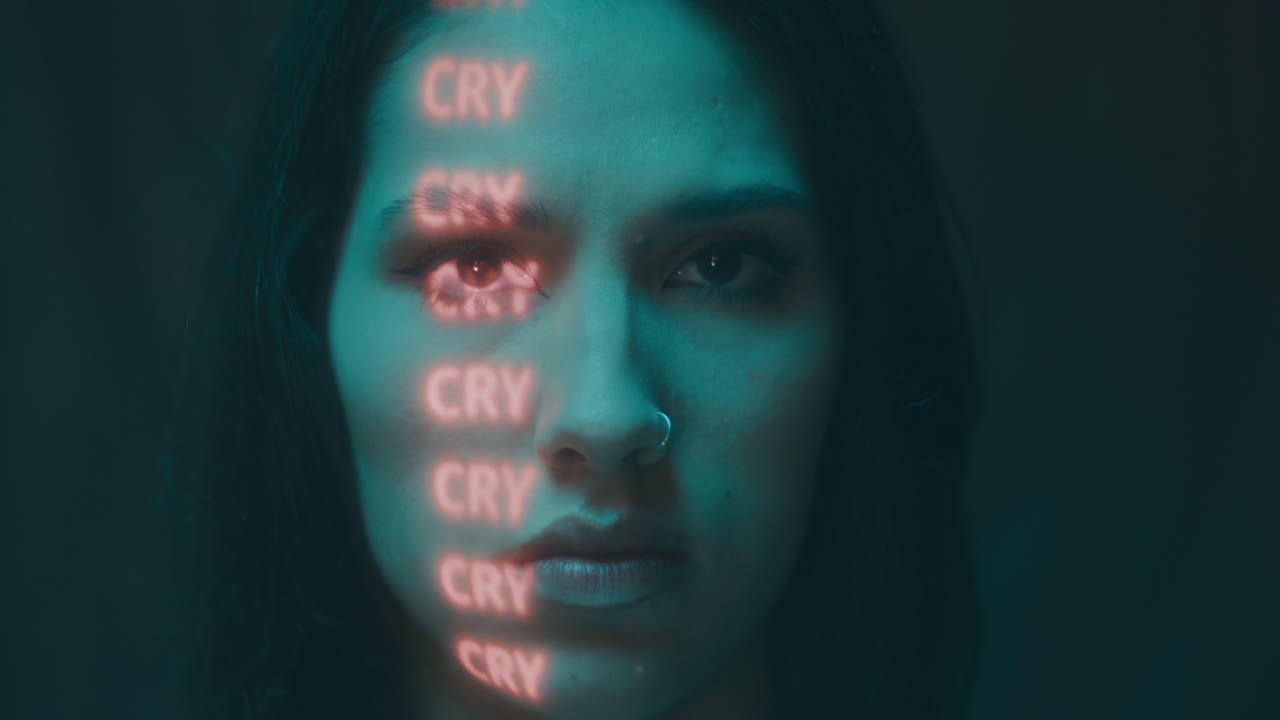 Woman with "CRY" projected on her face