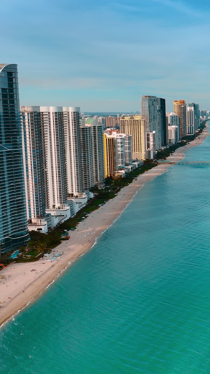 Calm blue waterscape of the Atlantic Ocean near the coast of America. Stunning view of Miami architecture on the coastline from top view. Vertical video