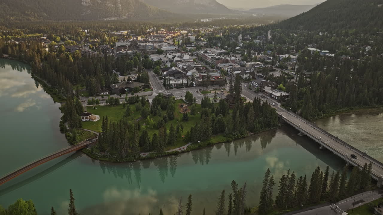 banff ab canada aerial v20 birds eye view flyover bow river a través de la ciudad a lo largo de la avenida banff capturando el pintoresco paisaje de la ciudad y los valles boscosos al amanecer - filmado con mavic 3 pro cine - julio 2023