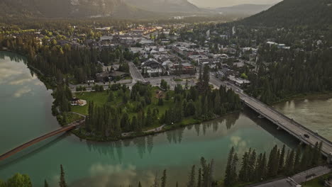 Banff,-AB,-Kanada,-Luftaufnahme-V20-Aus-Der-Vogelperspektive,-Überflug-über-Den-Bow-River-über-Die-Stadt-Entlang-Der-Banff-Avenue,-Fängt-Malerische-Stadtbilder-Und-Bewaldete-Täler-Bei-Sonnenaufgang-Ein-–-Aufgenommen-Mit-Mavic-3-Pro-Cine-–-Juli-2023