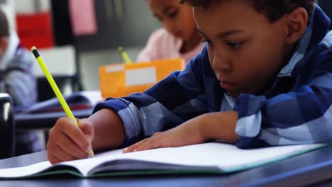 Attentive-schoolkids-doing-their-homework-in-classroom