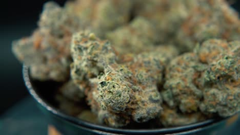 a macro dreamy steady shot of a cannabis plant, hybrid orange strains, sativa ,marijuana flower, on a rotating stand, slow motion, 4k video, studio lighting