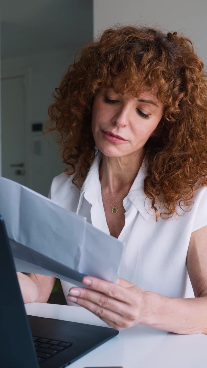 Donna concentrata che legge documenti alla sua scrivania
