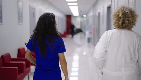 two medical professionals walking in a hospital hallway