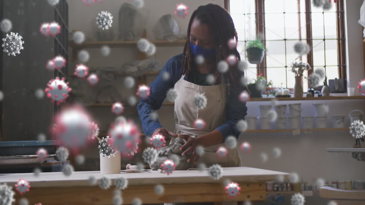 얼굴 마스크를 쓰고 있는 아프리카계 미국인 여성 위의 바이러스 세포의 애니메이션