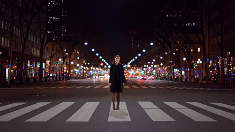 woman standing in city street at night