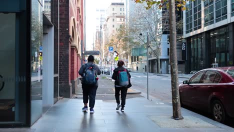 two people walking down a city street