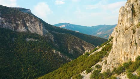 aerial flyby backwards in mountain range discover rocky steep peaks