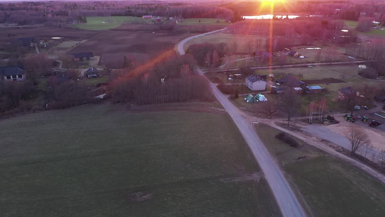 Countryside road in small town with red sunset, aerial drone view