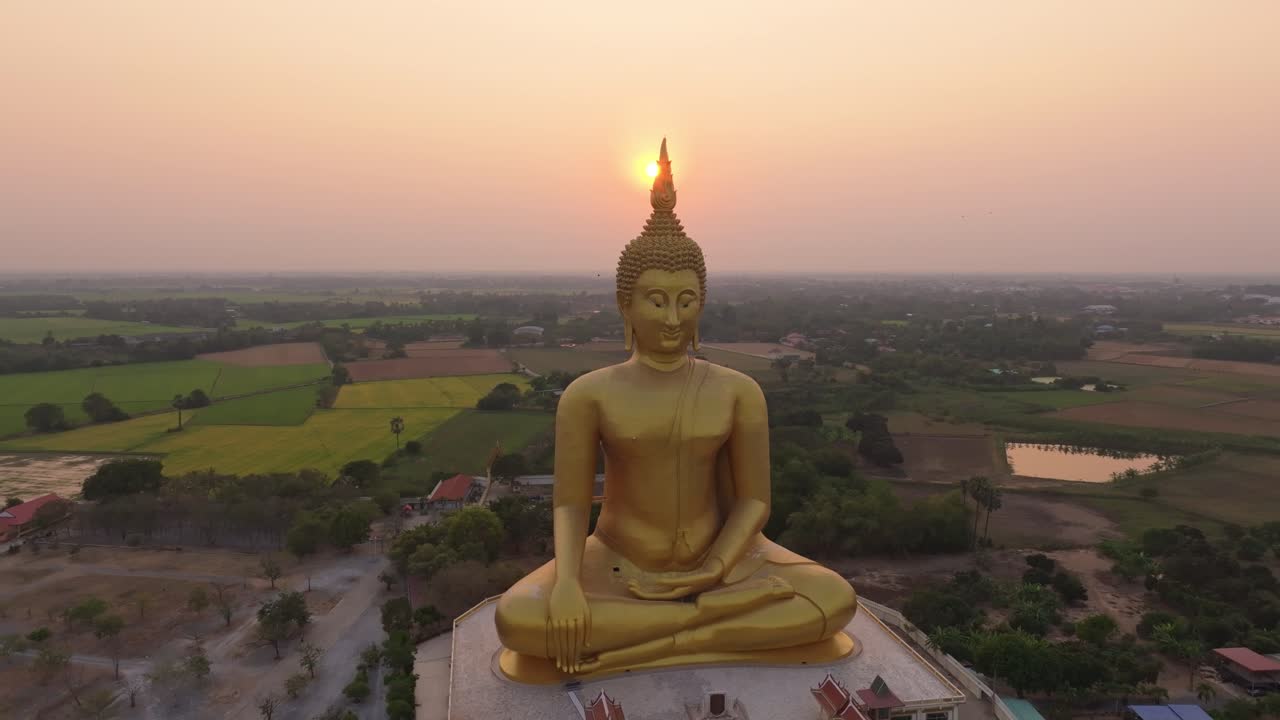 Scorcio aereo di un Buddha imponente sotto un cielo all'alba, Tailandia