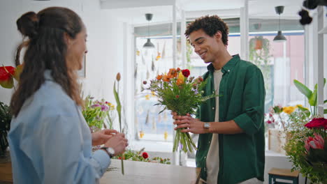 el cliente sonriente compra la composición floral en la tienda de ramos. concepto de floristería.