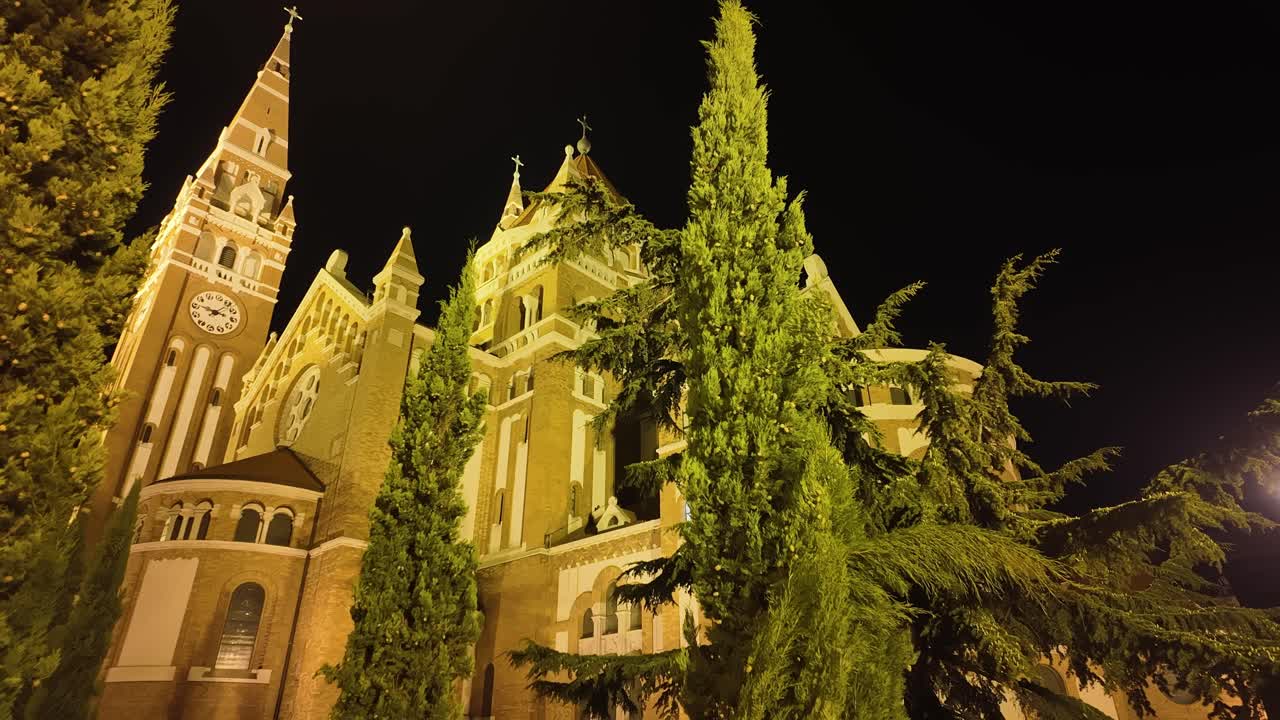 The impressive building and tower of the Szeged Cathedral from behind at night in Hungary