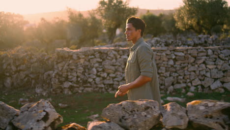 Thoughtful-guy-walking-stone-wall-place-closeup.-Farmer-on-plantation-vertically