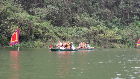 turistas remando en un barco en el río con bandera