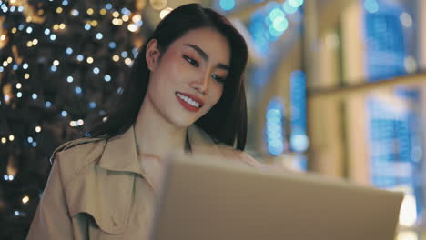 woman working on laptop at night in city