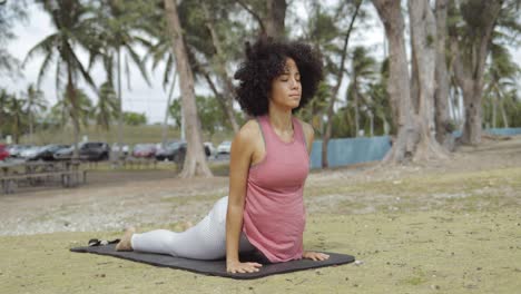 Confident-black-woman-stretching-on-mat