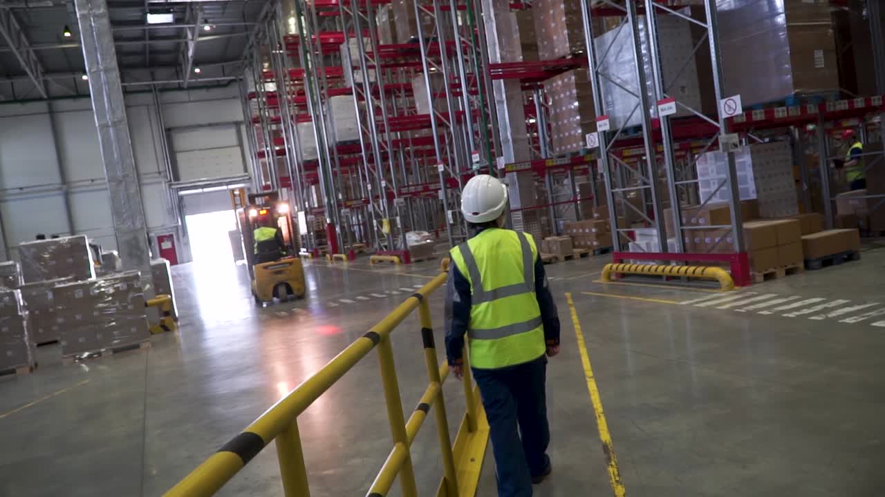 trabajador de almacén y carretilla elevadora en un centro de distribución