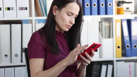 mujer que utiliza un teléfono inteligente en un entorno de oficina