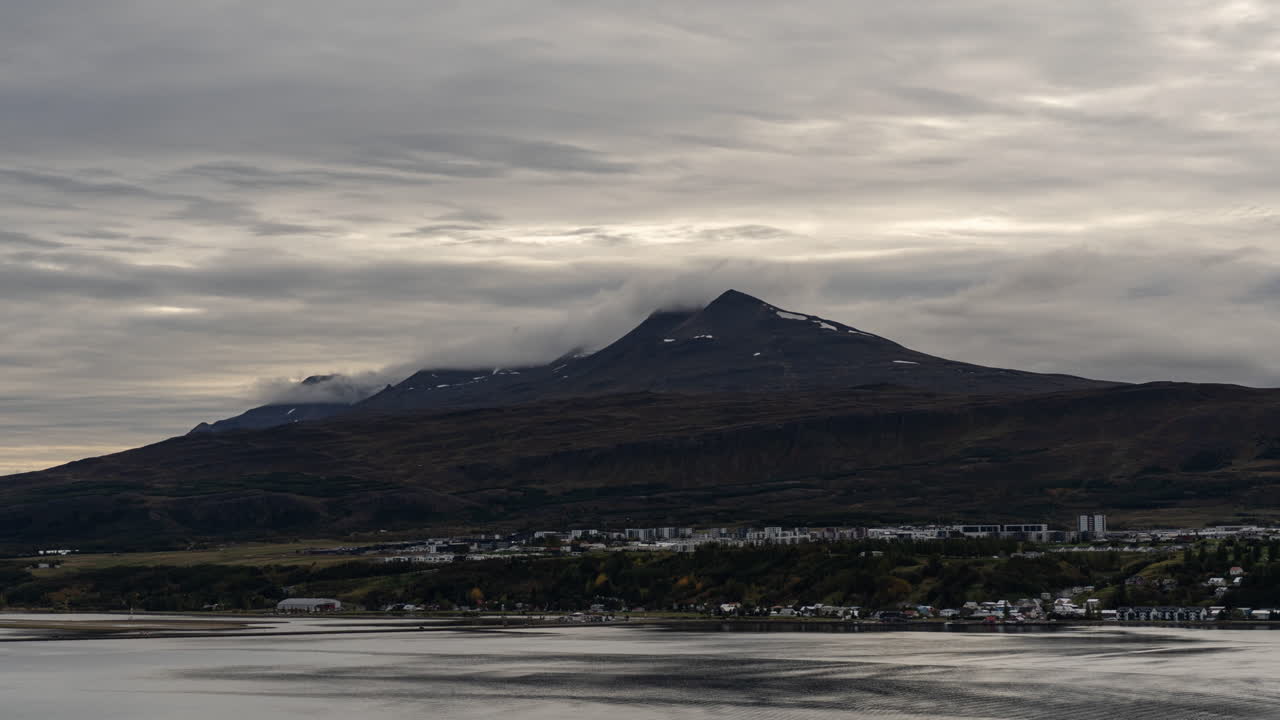 산꼭대기가 있는 마을 위의 구름 timelapse
