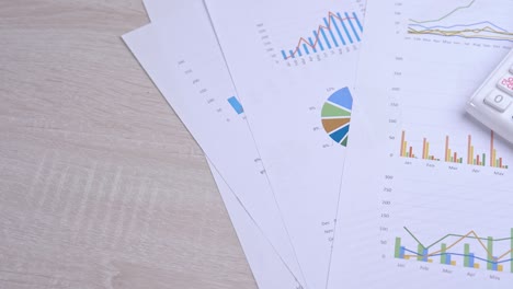 white calculator and report with chart and graph, concept of annual financial profit overview, banking and statistic, truck right, macro, close up